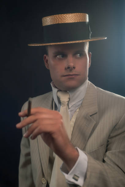 istock Man wearing boater hat and suit smoking cigar. 1286097938