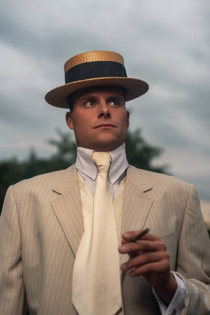 istock Man wearing boater hat and suit standing outside. 1286097963