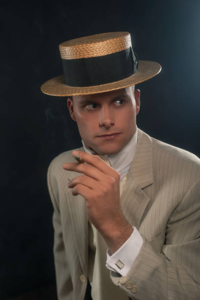 istock Man wearing boater hat and suit smoking cigar. 1286097964