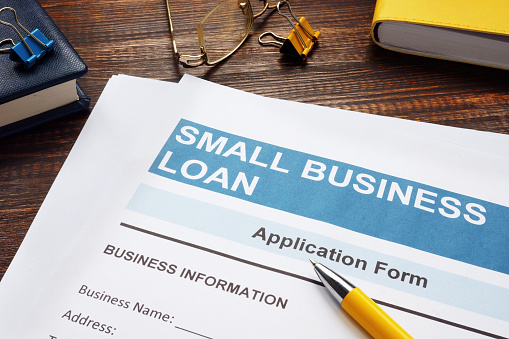 Small business loan application on the wooden surface and documents.