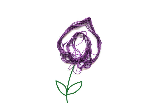 Purple flower made of thread on white background. Stem and leaves painted. Copy space.