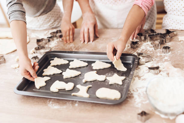 istock Women's and children's hands lay out cookie biscuits for deco in kitchen. 1286099843