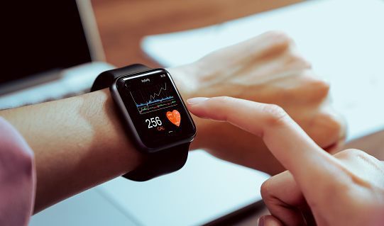 Primer plano de la mano tocando reloj inteligente con la aplicación de salud en la pantalla, gadget para el estilo de vida activo fitness. photo