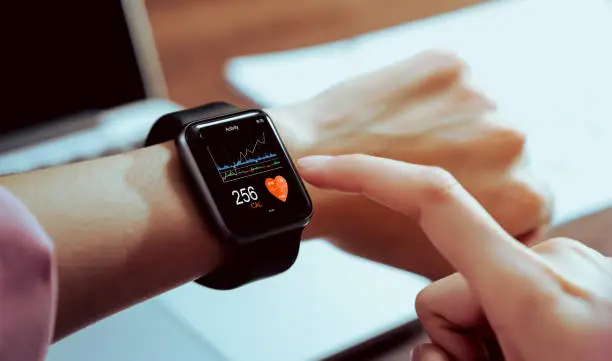 Close up of hand touching smartwatch with health app on the screen, gadget for fitness active lifestyle.