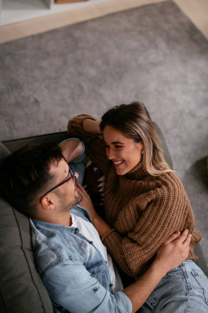 istock Young loving couple relaxing on sofa together. 1286101544