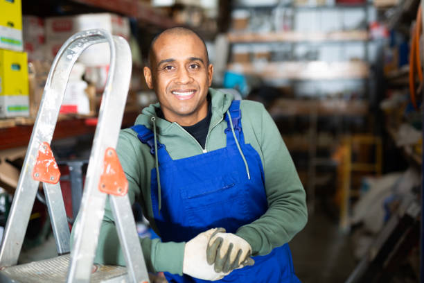 istock Positive warehouse worker stands next to stepladder and tool shelves in hardware store 1286103613