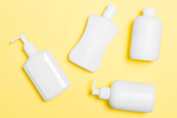istock Set of White Cosmetic containers isolated on yellow background, top view with copy space. Group of plastic bodycare bottle containers with empty space for you design 1286107906