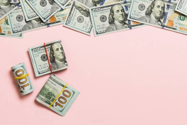 istock Heap of hundred Dollar Bills on colored background top view, with empty place for your text business money concept 1286107924