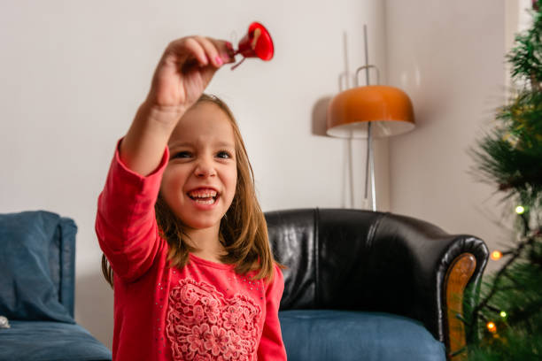 Child holding a Christmas bell in her hand