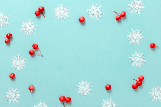 istock Christmas pattern. White snowflakes, red berry in Christmas composition on pastel blue background for greeting card. Winter festive composition with copy space. 1286112497