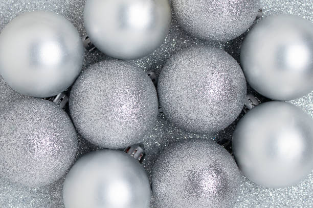 istock Christmas balls texture on a silver glittering background. 1286112553