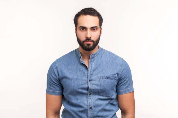 Portrait of attentive self confident bearded man looking at camera with serious expression, unsmiling determined business man