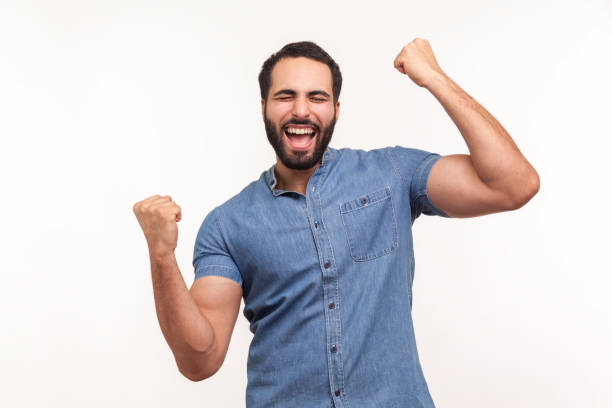 istock Euphoric thrilled man with beard screaming hurray raising hands up, celebrating his triumph and victory, extremely satisfied with success 1286112776