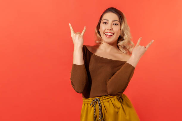 istock Joyful girl showing devil horns, rock and roll hand gesture. 1286112902