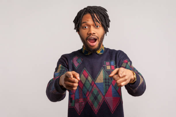 istock Wondered african man with dreadlocks and beard pointing fingers at camera with widely open mouth and big eyes, shocked and surprised with your success 1286112950