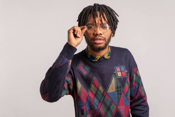 istock Closeup curious african man with dreadlocks adjusting his glasses for better vision, trying to peep secrets, spying 1286112953