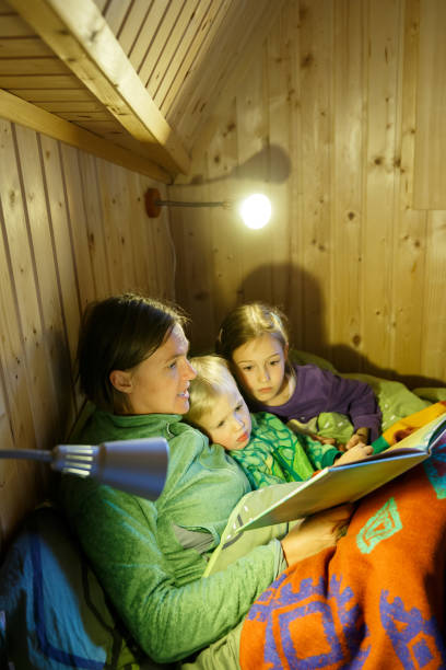 mother reading bedtime stories to her kids before going to sleep. - 3666 imagens e fotografias de stock