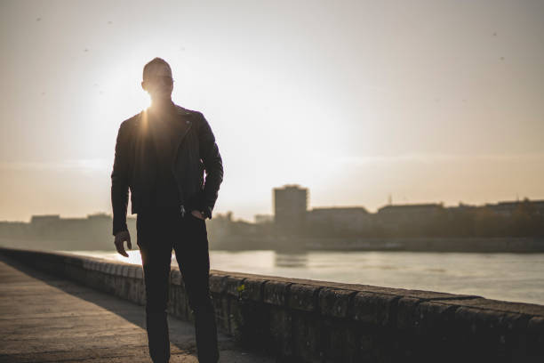 istock Young man relaxing and walking near river 1286115912