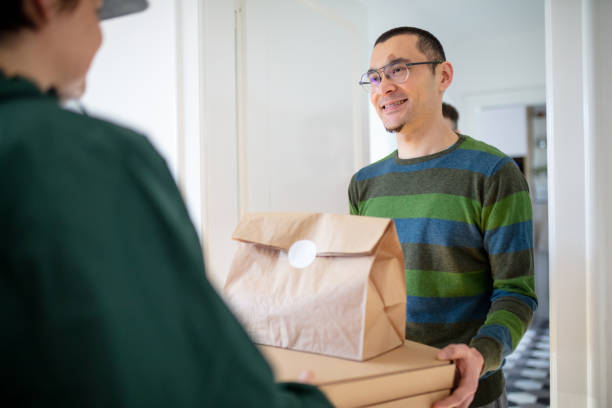 istock Smiling young man taking pizza delivery at the door 1286116727