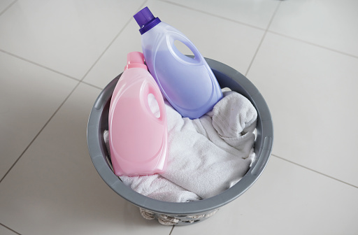 High angle shot of a washing basket filled with clean laundry and two bottles of fabric softener