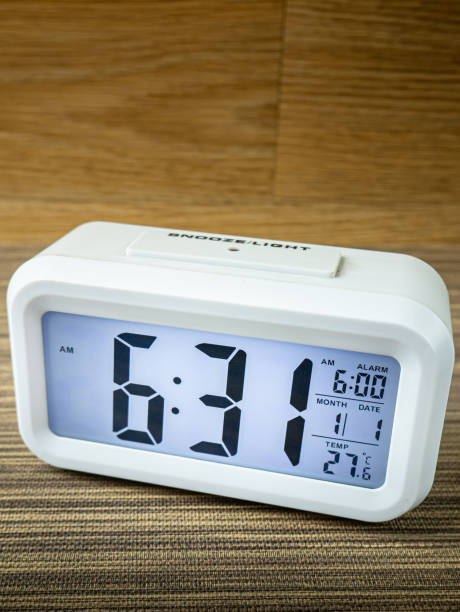 istock The white alarm clock digital numbers on wood table. 1286118965