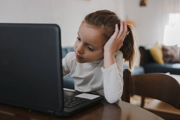 istock Child learning at home using laptop in living room 1286119763