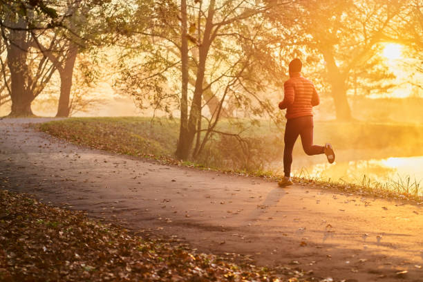 istock Athletic man running in the park during fall autumn morning 1286120055