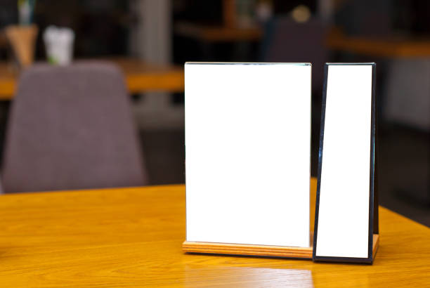 istock Tablet with empty space for text. Blank or layout for design. Mockup for advertising. White plate on a wooden table. Blurred bar interior on background. 1286120710