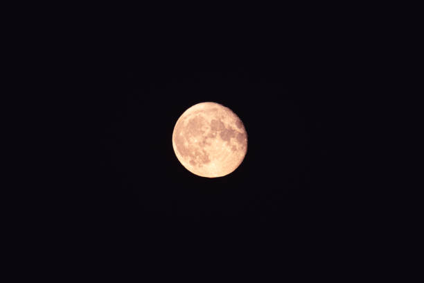 istock Bright light orange yellow full moon zoom on dark sky 1286124040
