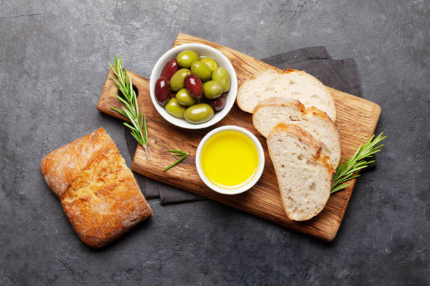 istock Ripe olives, olive oil and ciabatta bread 1286124080