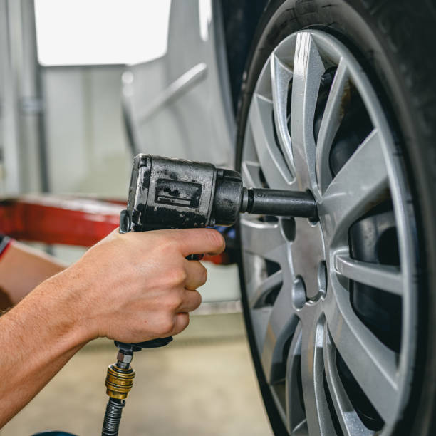 istock Car mechanic is changing tire 1286125216
