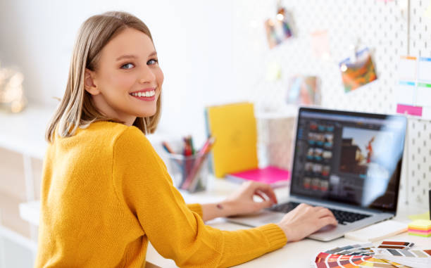 istock Happy designer using laptop at home 1286126670