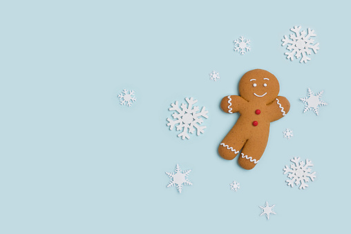 Classic gingerbread cookie hero isolated on blue with decorative show flakes