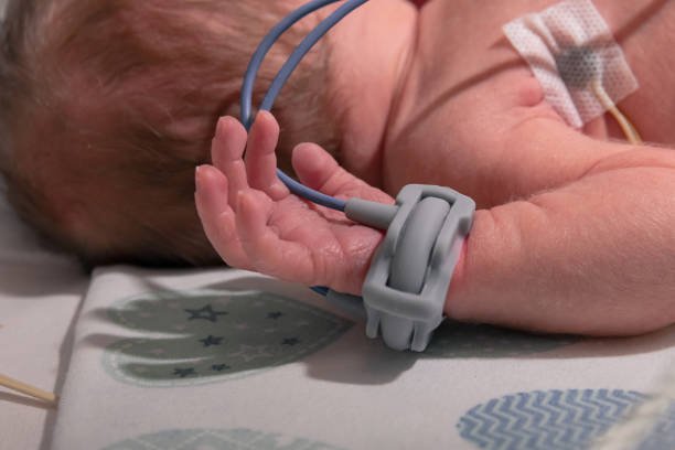 Premature baby hand with a premature infant pulse oximeter, selective focus. Newborn is placed in the incubator, baby born prematurely. Neonatal intensive care unit Premature baby hand with a premature infant pulse oximeter, selective focus. Newborn is placed in the incubator, baby born prematurely. Neonatal intensive care unit oxygen monitor stock pictures, royalty-free photos & images