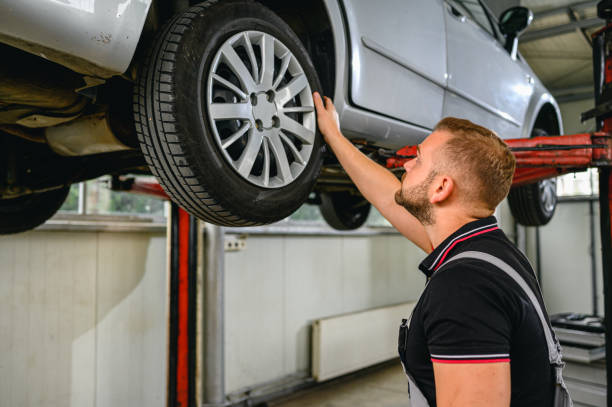 istock Car mechanic is changing tire 1286128028
