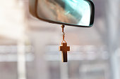 Christian cross hangs on the mirror in the car.
