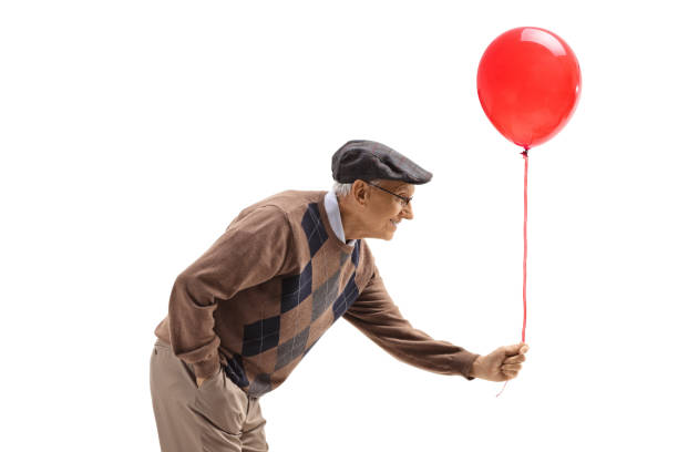 istock Elderly man handing a red balloon 1286129655