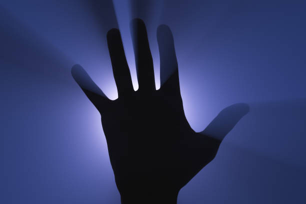 istock Human hand silhouette in the light of a spotlight. 1286129811