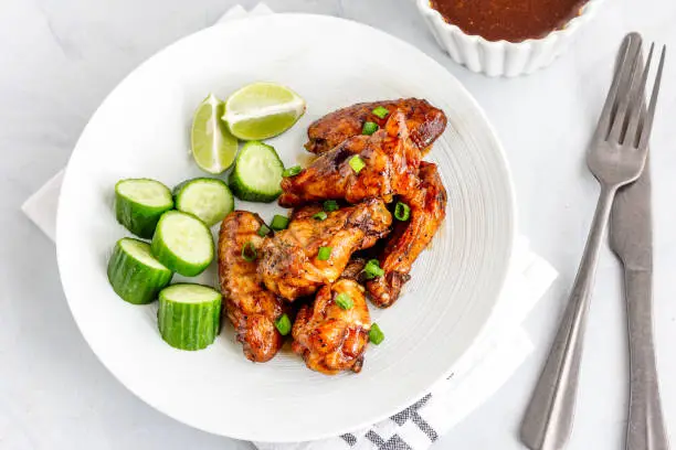 Sweet and Spicy Thai Chicken Wings with Condiment Directly Above Photo on White Background