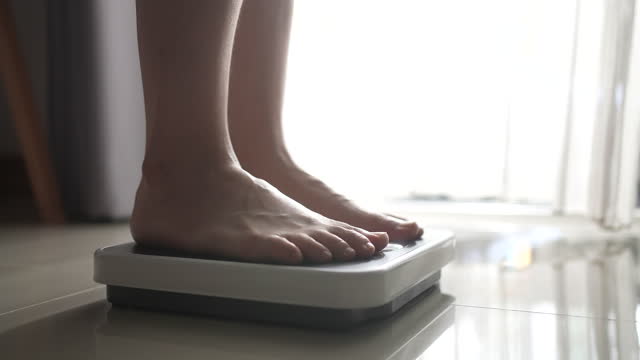 Close-up Foot of Woman walking on a body weighing scale