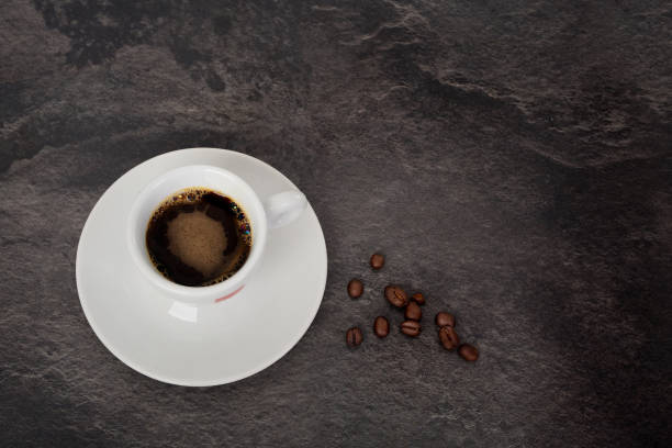 istock Top view of a white espresso cup and coffee beans. 1286133241