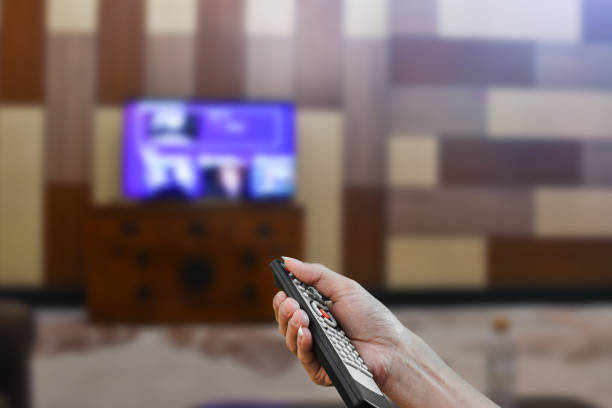 istock Close up hand holding remote control a television. Selective focus 1286133424