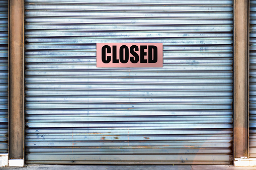 Closed sign on dirty metal door during crown lock