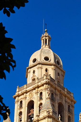 Tower of the Murcia Cathedral emerges over the buildings to be seen by tourists