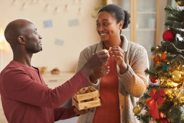 istock Happy African-American Couple Decorating Christmas Tree 1286136395