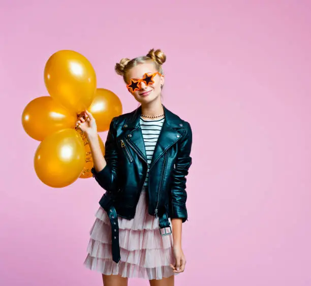 Photo of Stylish teenege girl holding gold balloons
