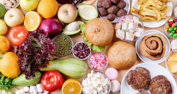 istock Fruit and vegetables vs sweets and fast food top view flat lay on orange background 1286138008