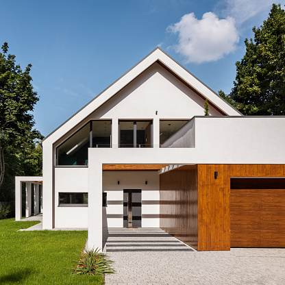 Beautiful and modern, white house with wooden panels on garage, exterior view