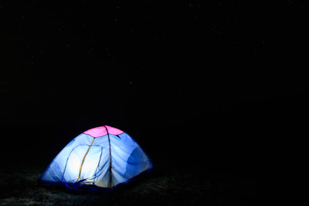 istock Illuminated blue tent at night under starry sky. Traveling and camping concept 1286139611