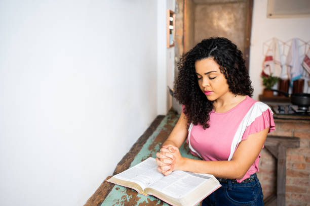 istock woman doing prayer - praying with eyes closed 1286139655